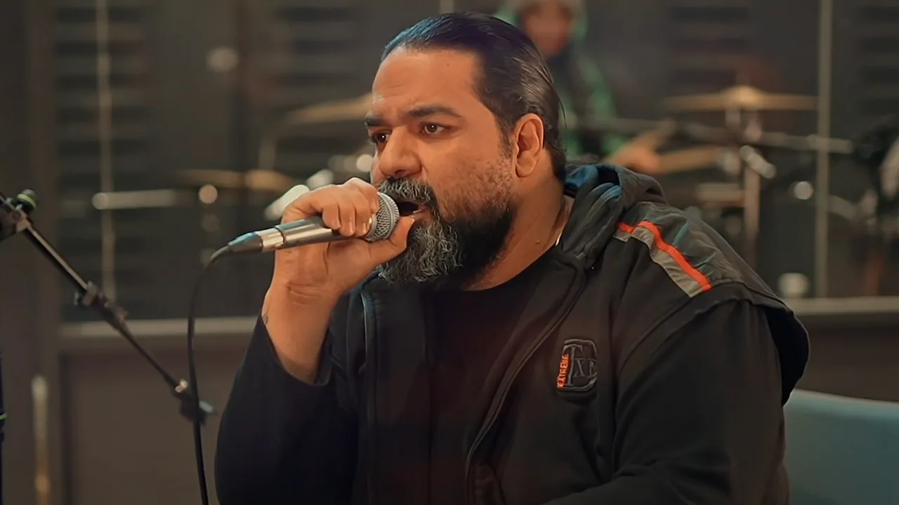 Singer Reza Sadeghi performing in a studio music video